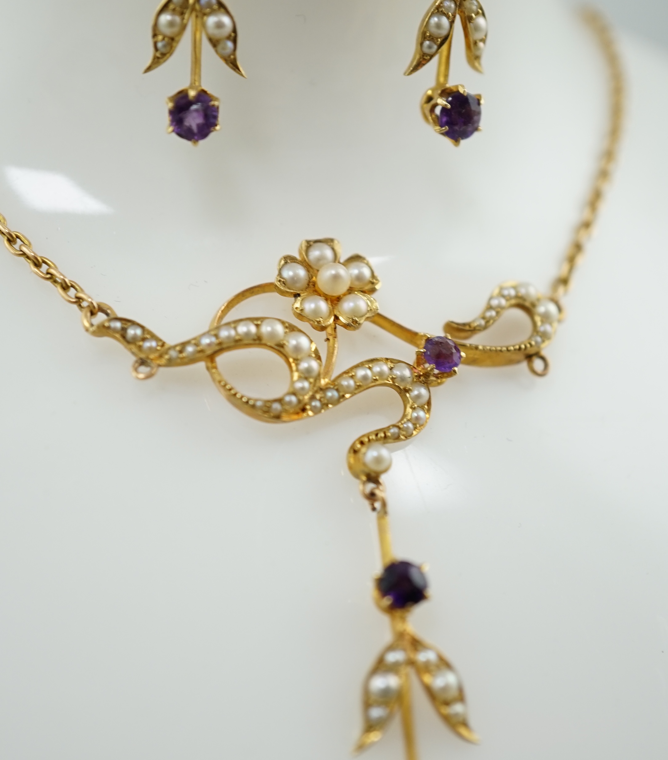 An Edwardian 15ct gold, seed pearl and amethyst set drop necklace and a pair of matching unmarked earrings